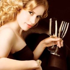 Afbeelding vrouw met champagne glazen in haar hand bij artikel champagne en cholesterol