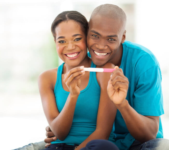 Afbeelding gelukkig stel met zwangerschapstest in hun hand bij artikel blijven liggen na zwangerschap