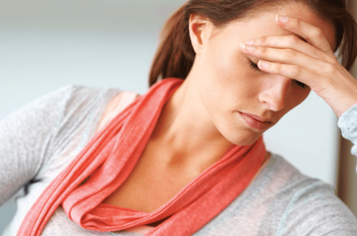 Afbeelding van vrouw met hoofdpijn hand voor ogen bij artikel over wat is migraine