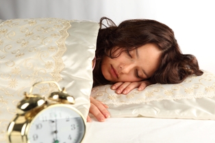 Vrouw ligt te slapen in bed bij artikel over te weinig slaap