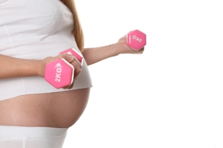 Afbeelding van zwangere vrouw met gewichtjes bij artikel bewegen tijdens zwangerschap